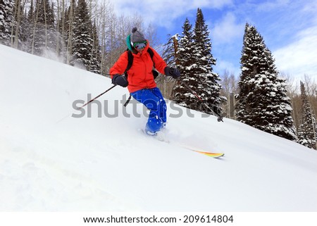 Smiling woman skiing fresh powder snow in the Utah backcountry, USA.
