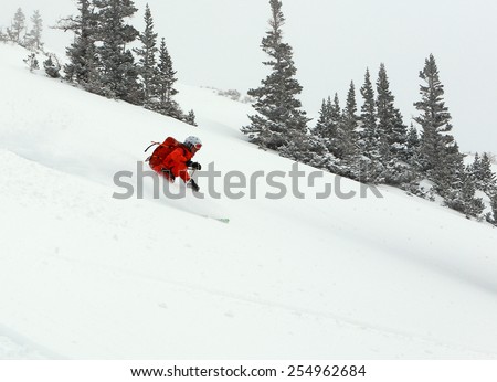 A woman skiing deep powder snow in the Utah mountains, USA.