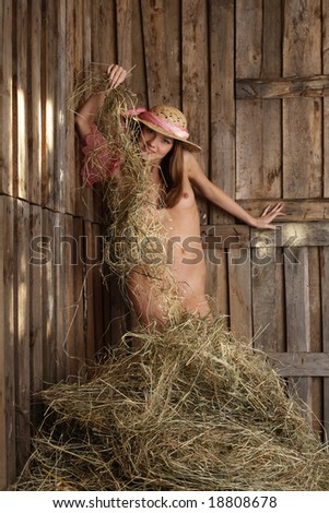 stock photo Beautiful bare girl in a pantry with a hay