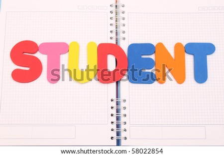 Plastic letters that spell out the words student on a book background.