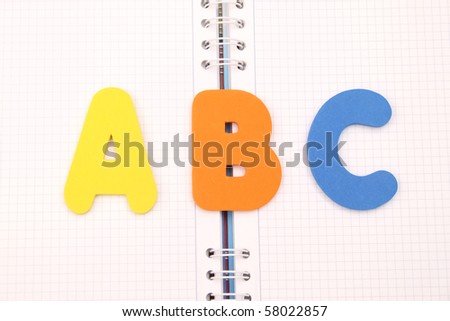 Plastic letters that spell out the words ABC on a book background.