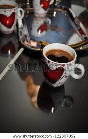 cups of coffee on a glass table in front of the tray and cups