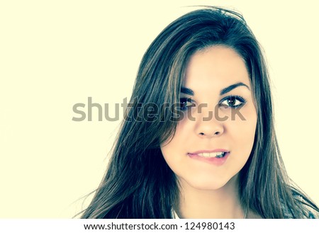close up portrait of beautiful brunettes who bites her lip on yellow isolated background