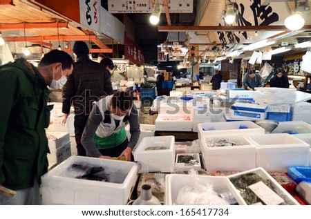 TOKYO - NOV 26: Seafood vendors at the Tsukiji Wholesale Seafood and Fish Market in Tokyo Japan on November 26, 2013. Tsukiji Market is the biggest wholesale fish and seafood market in the world.