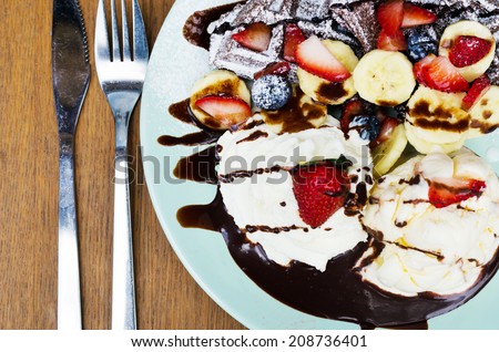 Ice cream, banana, strawberry, raspberry, chocolate waffles with chocolate sauce, Top view