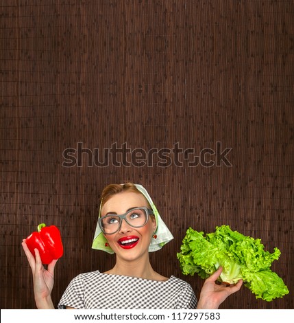 Funny woman cook holding salad and sweet pepper, space for yuor text
