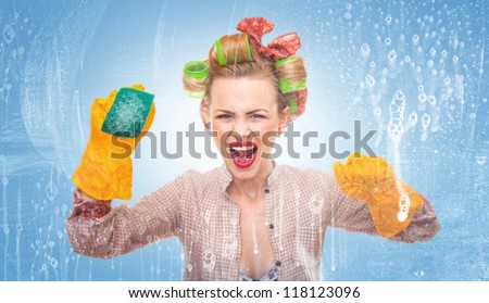 Funny housewife with scubberr cleaning window / glass . Foam / soap on glass