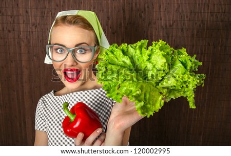 Funny woman cook holding salad and sweet pepper, close up of a housewife