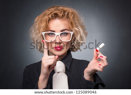 Close-up of young teacher with finger up holding chalk. Formal professor female