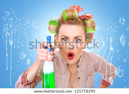Funny housewife / woman behind window spraying the cleaner on glass, foam / soap on glass