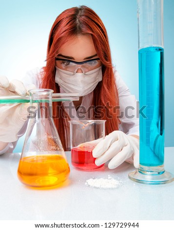 Female medical or scientific researcher looking at a liquid clear solution