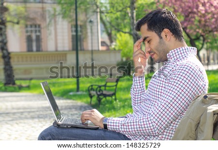 Headache, male with laptop. Profile - sideways shot