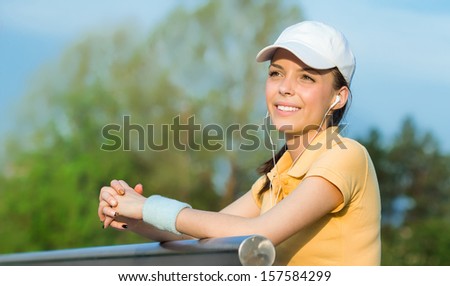 Happy young sports woman hear music, close up profile of vitality female wearing cap