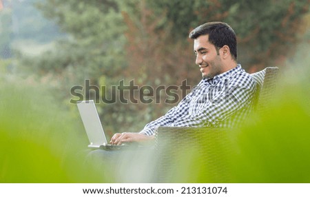 Profile of a young man with laptop, outdoor - outside. Side view sideways
