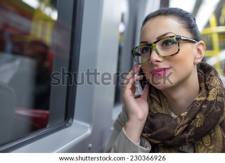 Woman commuter talking on cell phone while taking bus to work