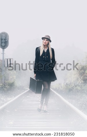 Young beautiful woman standing on railway. Creative mystic art photo
