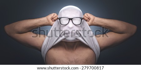Anonymous man. Human hiding her face with t-shirt - undershirt. Creative image, idea creativity concept. Funny guy wearing eyeglasses