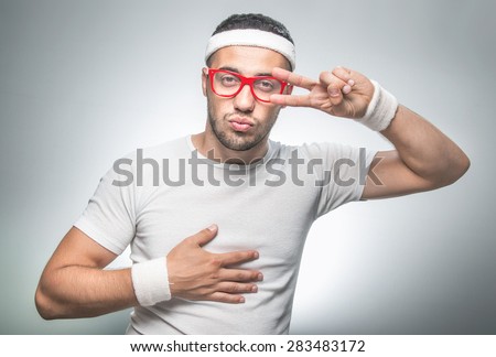 Funny man doing fitness\\
Isolated on gray background. \\
Nerd funny sport man with facial expression