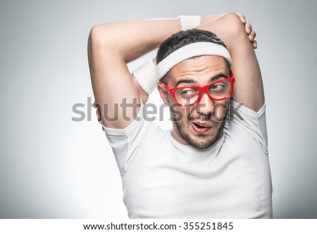 Close up funny man doing aerobics isolated on gray background, studio shot. Nerd sportman