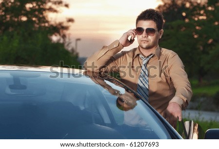Successfull businessman on phone, sunset on back