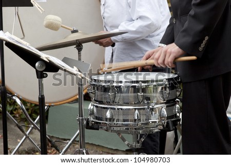 Drummer playing the snare drum, bass drum in background.