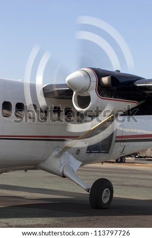 Motion blur of spinning propeller blades on turbo prop aircraft engine.