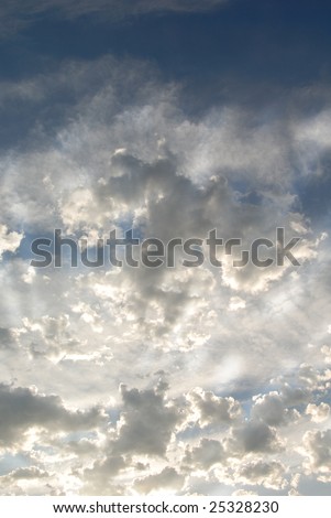 Sun\'s Rays on Layers of bright clouds on blue evening Summer sky