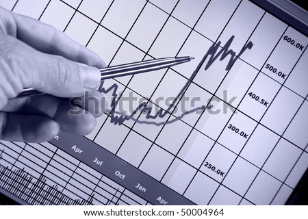 Financial chart on computer monitor, market's rising, hand and pen pointer