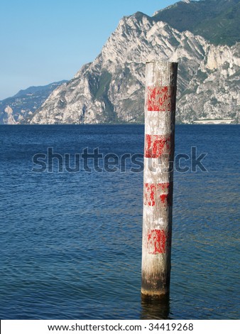 Red and white wooden pole in Lake garda, Italy