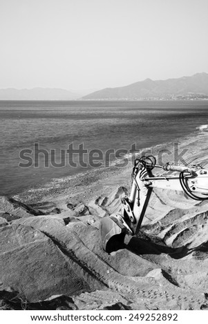 Black and White image of Road Scraper working near water