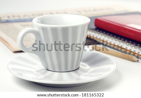 coffee cup pencil notebooks and newspaper on white table