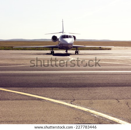 parked private airplane on the runway. white civic jet