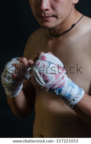 portrait of a thai boxing in a fighting stance.