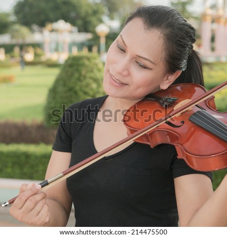 Smiling woman playing the violin.