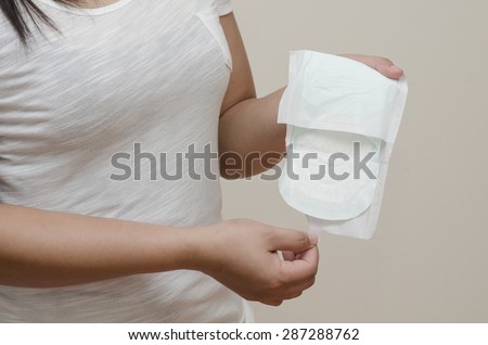 woman\'s hand holding a daily sanitary pad.