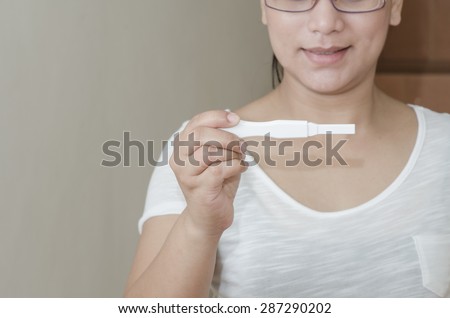 pregnancy test positive result smiling woman.