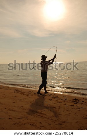 Silhouette of fisherman casting at sunset