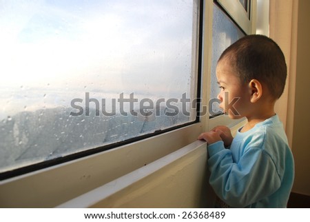 cute child watching the dramatic sunrise on the window