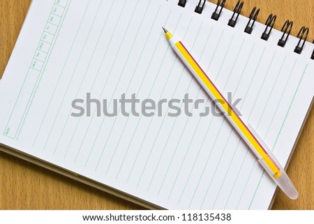 Notebook and pen on the wooden floor.