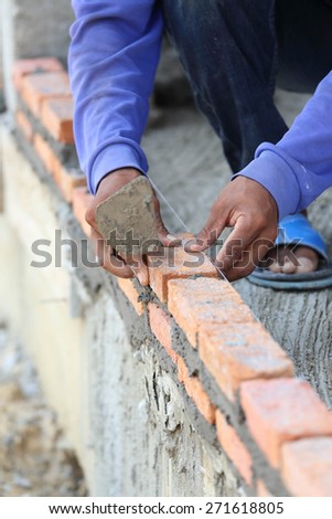 Workers masonry Clay brick to wall.