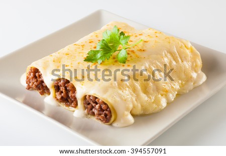 Delicious meat filled pasta on a plate. Italian cannelloni, Spanish canelones.