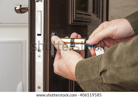 Locksmith repairing the lock on a house door