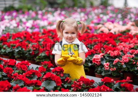 Lovely girl holding flowers in garden center.
