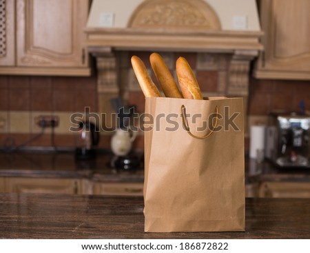 Loaf of white bread packaged in a paper bag on the kitchen