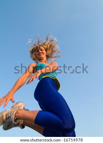 Beautiful fit blond girl jumping smiling cheerful