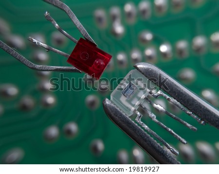 Optocoupler and LED in pincers electronic assembly macro