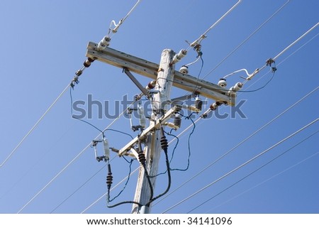 transformer on top of a wooden pole with electric wires