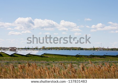 Acres of farmland covered with solar panels, produce energy from the sun at this large scale solar farm in Sarnia Ontario, Canada.