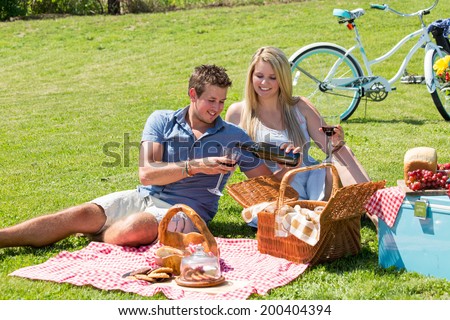 A young couple shares a happy moment picnicking on the grass in the countryside
