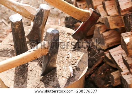 A large block of wood holds several axes for wood splitting during spring clean up weekend at the cottage